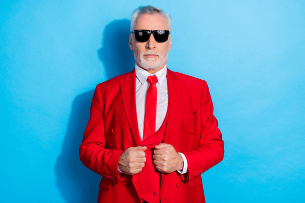 Photo of confident successful pensioner man focused look camera wear sunglass red tux isolated blue color background. - Foto, imagen