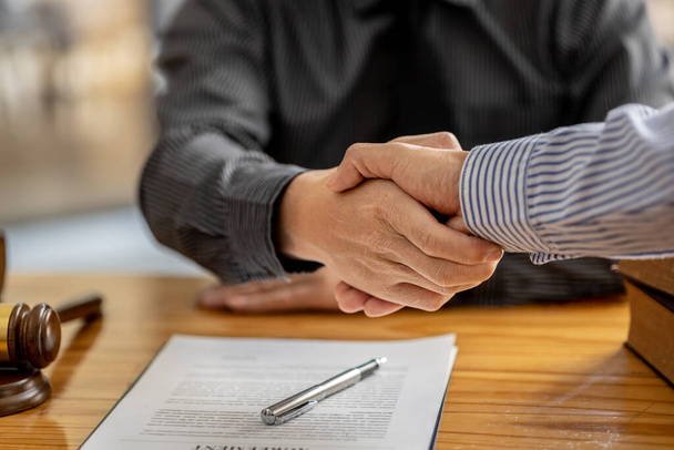 Lawyers shake hands with clients who come to testify in the case of embezzlement from business partners who jointly invest in the business. The concept of hiring a lawyer for legal proceedings. - Фото, зображення