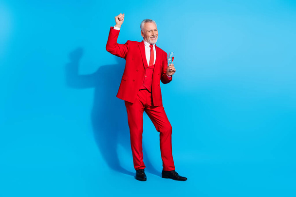 Photo of carefree funky man hold champagne golden wine dance wear red tux shoes isolated blue color background. - Foto, immagini