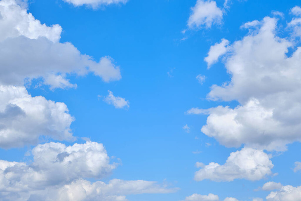 Background cumulus clouds against a blue sky illuminated by sunlight - Fotó, kép