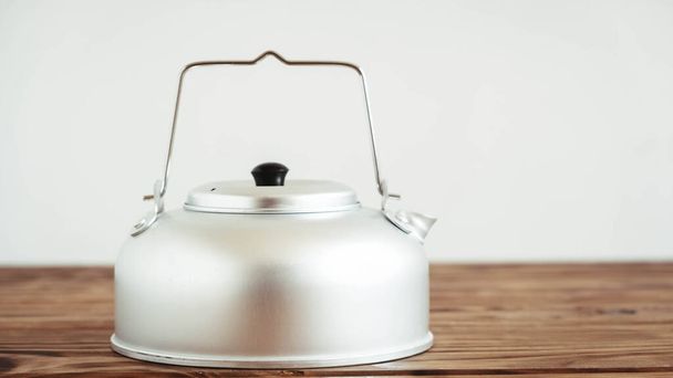 Metal kettle for hiking on a wooden table background - Valokuva, kuva