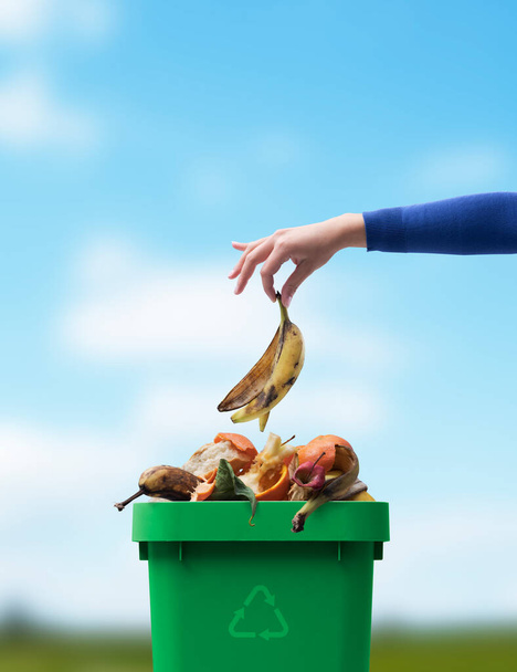 Woman putting organic biodegradable waste in a recycling bin, separate waste collection concept - Foto, Bild