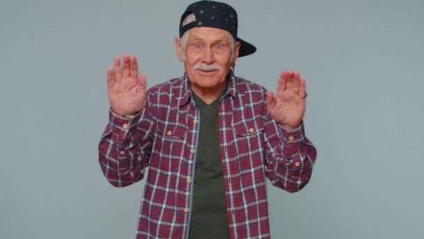 Senior man smiling friendly at camera and waving hands gesturing hello or goodbye, welcoming - Photo, image