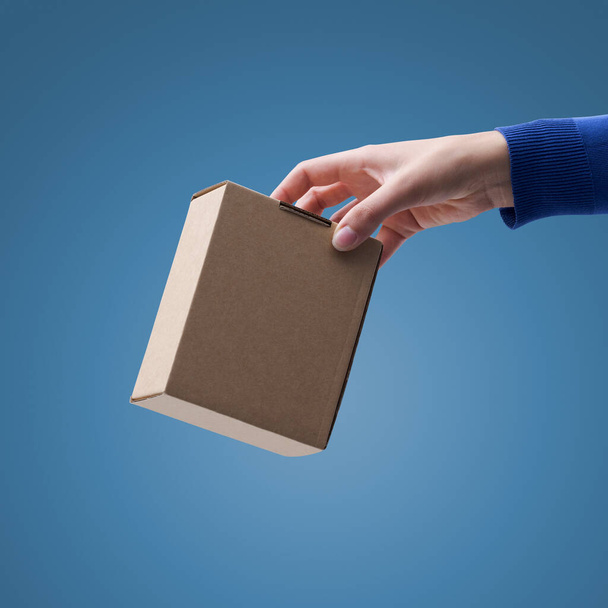 Hand holding a carton box, waste collection concept - Фото, изображение