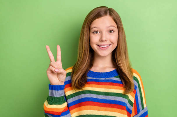 Portrait of attractive funny tender girly cheerful girl showing v-sign good mood isolated over bright green color background. - Foto, imagen
