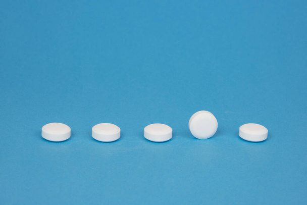 White pills antibiotic round on blue background - Фото, изображение
