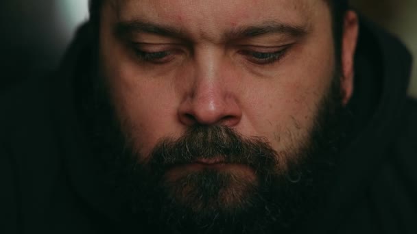 Ein Mann mit Bart blickt traurig in die Kamera, statische Kamera, Nahaufnahme des Gesichts - Filmmaterial, Video