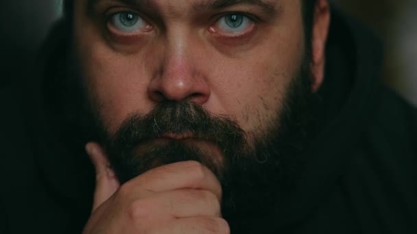 Ein Mann mit Bart blickt traurig in die Kamera und berührt seinen Bart, statische Kamera, Nahaufnahme des Gesichts - Filmmaterial, Video