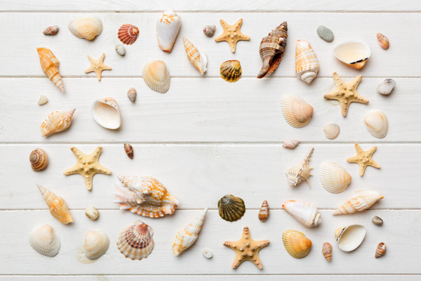 Concepto de hora de verano Composición plana con hermosas estrellas de mar y conchas de mar en la mesa de colores, vista superior con espacio de copia para el texto. - Foto, Imagen