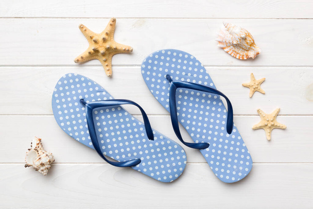 Flat lay composition with flip flops and seashell on colored background. Space for text top view. - Photo, Image