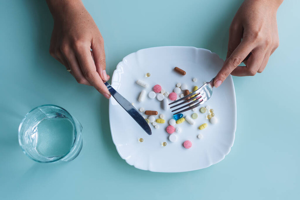 Woman is eating a pills and drugs. Concept of healthy food, diet. - Fotografie, Obrázek