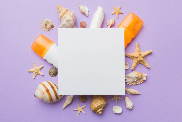 Summer time concept with blank greeting card and blank white paper on colored background. Seashells from ocean shore in the shape of frame separated with space for text top view. - Zdjęcie, obraz