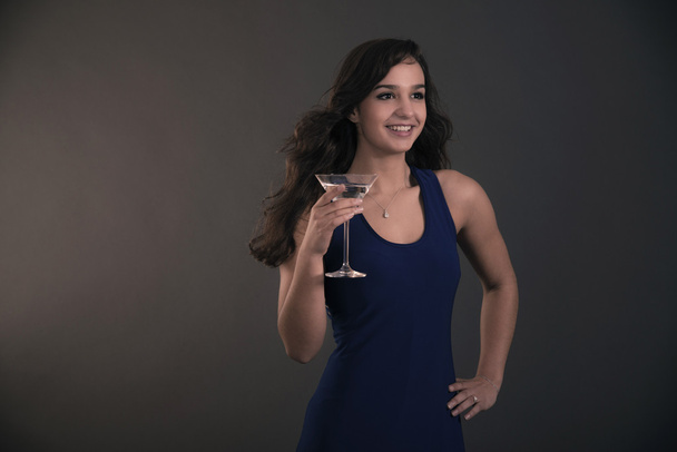 Kaunis brunette teini tyttö tilalla cocktail lasi yllään sininen
 - Valokuva, kuva