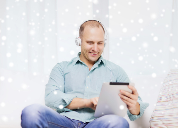 smiling man with tablet pc sitting on couch - Φωτογραφία, εικόνα