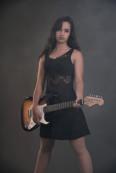 Chica de rock adolescente con guitarra eléctrica. Vestido negro
. - Foto, Imagen