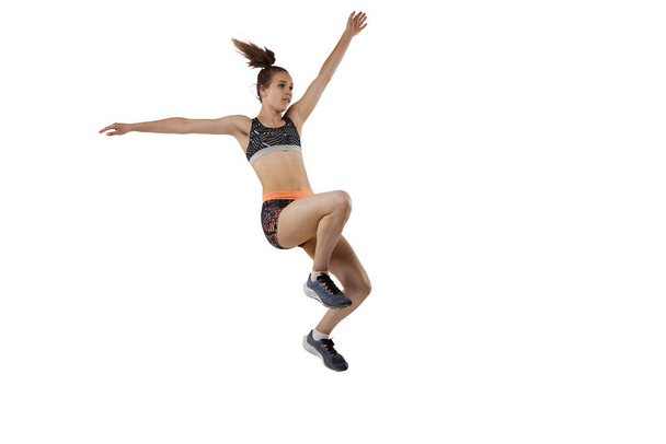 Development of movements in long jump sport. One professional female athlete in sports uniform jumping isolated on white background. Concept of sport, action, motion, speed. Copy space for ad - Фото, зображення