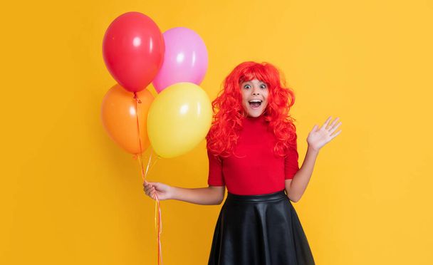 happy teen girl with party balloon on yellow background. wow. - 写真・画像