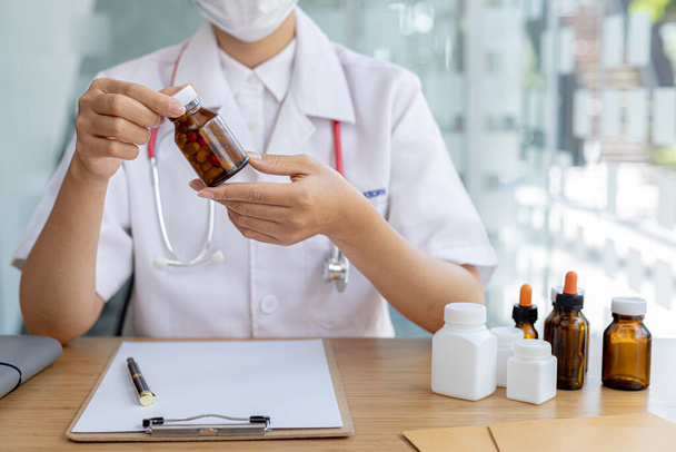 Pharmacy is holding a bottle, a public health professional with the most expertise in medicine in the health profession, responsible for all medicines, their procurement, production, and distribution. - Photo, Image