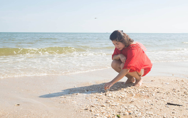 Frau sitzt im Sand am Strand. - Foto, Bild
