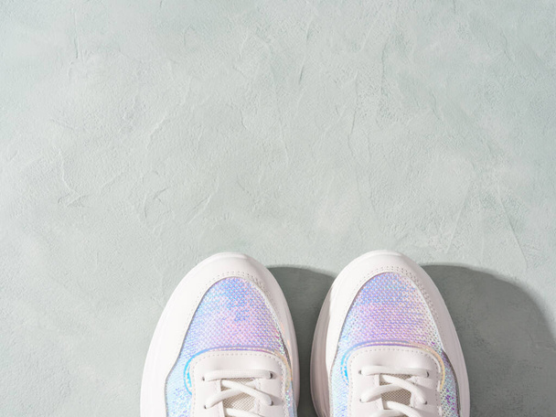 Sneakers bianche pastello con paillettes su podi geometrici su fondo turchese - Foto, immagini