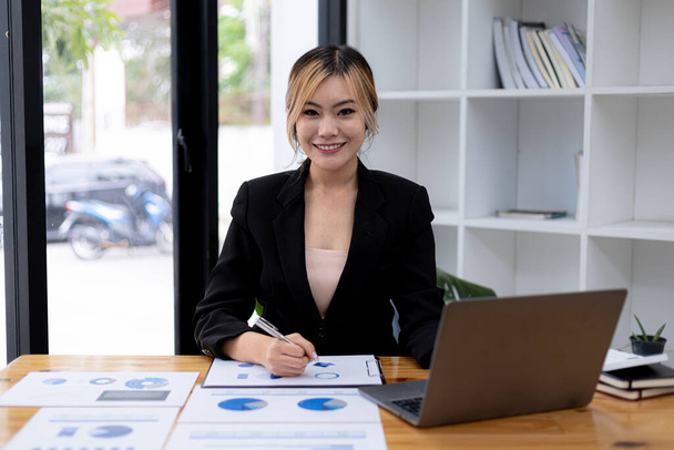 Asian woman sitting in a private office, she is a young businesswoman, female leader, Asian woman consent to be a leader and leader, working woman. Concept of business woman. - Foto, imagen