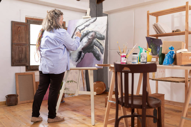 Maturo artista donna trascorre il suo tempo libero sviluppando le sue abilità di pittura presso il suo laboratorio - Foto, immagini
