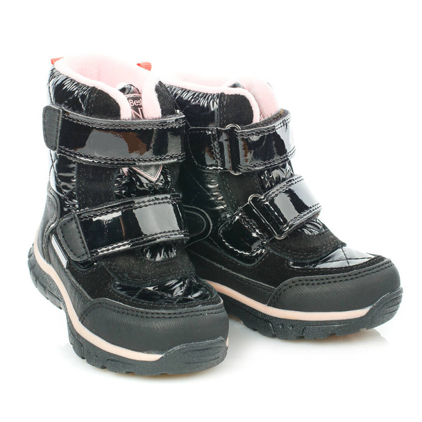 Stivali neri impermeabili lucidi invernali per bambini con velcro e pelliccia rosa per una bambina isolata su uno sfondo bianco. Foto per i siti web di aziende che vendono scarpe e vestiti. - Foto, immagini