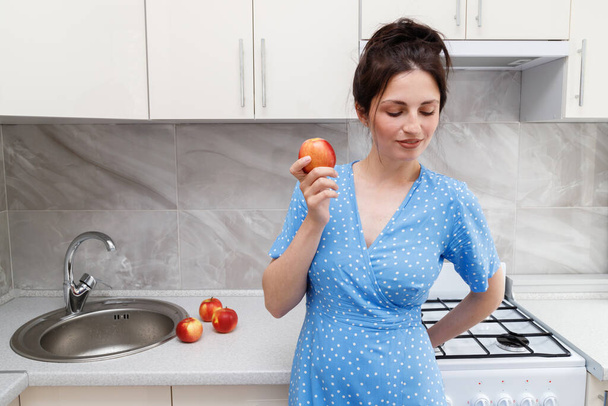woman with apples near the sink in the kitchen - Φωτογραφία, εικόνα