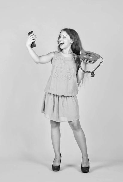 cute kid hold retro and modern phone for talking, selfie. - Foto, imagen