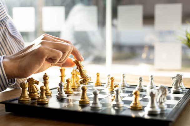 Person playing chess board game, business man concept image holding chess pieces like business competition and risk management, planning business strategies to defeat business competitors. - Foto, immagini