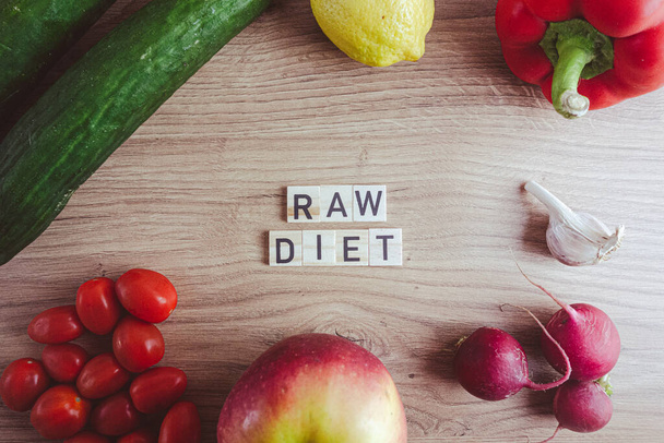 Concepto de dieta de alimentos crudos. Texto de bloques de madera con verduras frescas y frutas en la mesa - Foto, imagen