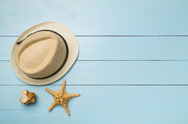 Wicker hat and seashells on wooden background, top view. - Фото, изображение