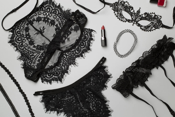 Set of black sexy lace lingerie with accessories on color background, top view. - Foto, Imagen