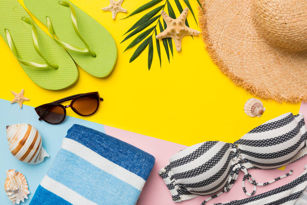 Accessoires de plage chapeau de paille et coquillage sur table colorée. Concept d'été fond. - Photo, image