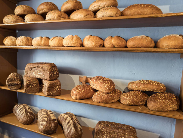 types of bread on the shelves in the bakery such as white bread, brown bread and wholemeal bread - Φωτογραφία, εικόνα