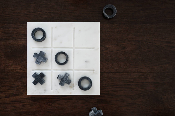 bovenaanzicht marmer Tic Tac Toe of OX bordspel op de houten tafel met kopieerruimte. concept van strategie, risico, concurrentie in het bedrijfsleven - Foto, afbeelding