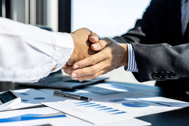 Close-up two business men holding hands, Two businessmen are agreeing on business together and shaking hands after a successful negotiation. Handshaking is a Western greeting or congratulation.  - 写真・画像