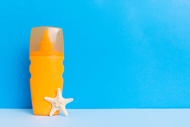 Acessórios de praia. Moisturiser protetor solar bronzeador garrafa loção para proteção da pele UVB no verão com conchas no fundo colorido. Preencha com espaço de cópia. - Foto, Imagem