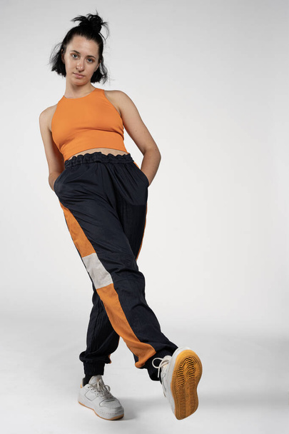 studio photo. Studio shot of a young woman dancer with blue and orange hip hop dance clothes - Foto, immagini