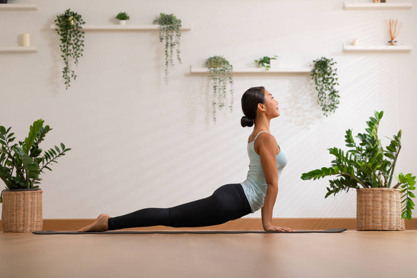 Wellness Vonzó ázsiai nő gyakorolja jóga Kobra póz otthon meditáció kényelmes és pihenni, Nyugodt egészséges fiatal nő mély lélegzet és meditáció jóga otthon, jóga koncepció - Fotó, kép