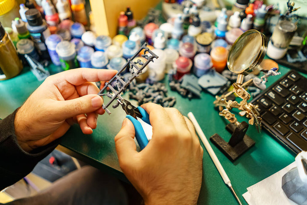 Homem cortando pequenos pedaços de miniaturas jogos para pintar à mão - Foto, Imagem