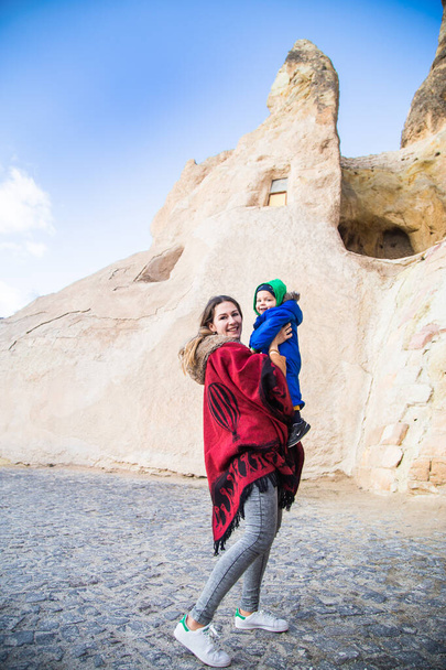 Madre e hijo viajando disfrutando de unas vacaciones en el desierto de Capadocia Turquía. Mamá y el niño turista en la ropa azul retrato al aire libre. Mujer feliz y niño activo senderismo vacaciones - Foto, imagen