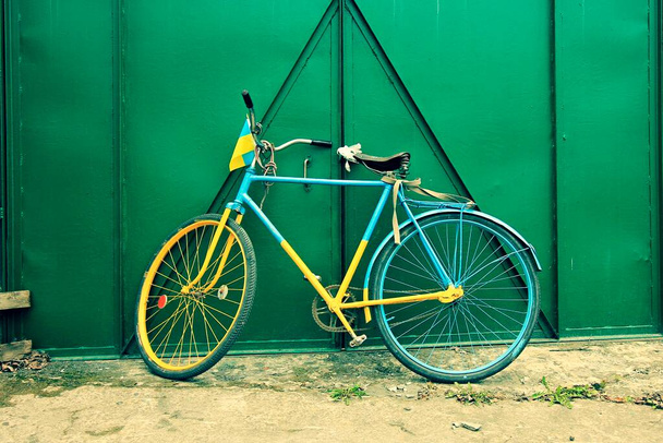 blue-yellow bicycle against the background  - Fotó, kép