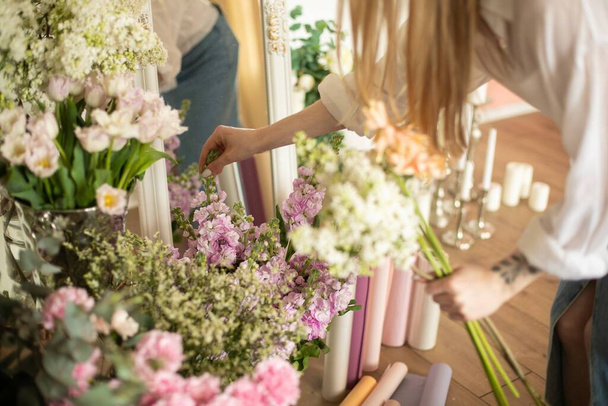 仕事中の花屋:異なる花のファッション現代的な花束を作る女性。高品質の写真 - 写真・画像