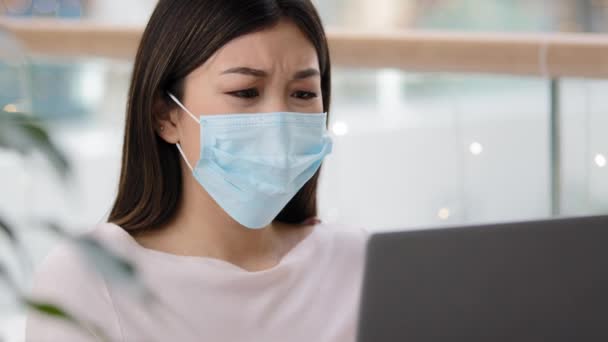 zdezorientowana azjatycka kobieta w masce medycznej czytanie złych wiadomości o covid19 pandemia otrzymać odmowy e-mail na laptopie depresja stres nieprzyjemny błąd online stracił egzamin awaria zwolnienie zawiadomienie utrata pracy - Materiał filmowy, wideo