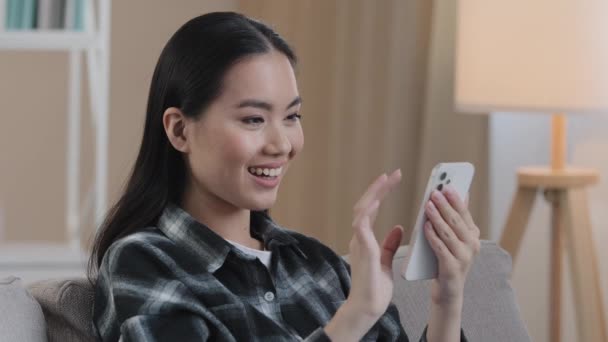 Gülümseyen mutlu Asyalı kadın telefon ekranına dokunuyor. Neşeli Koreli kız. İnternetten alışveriş yapmayı seçiyor. - Video, Çekim