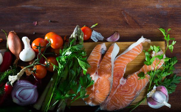Natural wooden background with fresh salmon steaks, vegetables, mushrooms and greens. Healthy food concept - Fotografie, Obrázek
