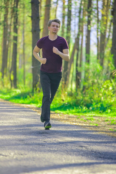 Running man jogging in city park at beautiful summer day. Sport fitness model caucasian ethnicity training outdoor. - Foto, immagini