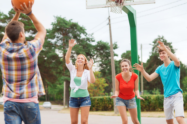 group of smiling teenagers playing basketball - Фото, зображення