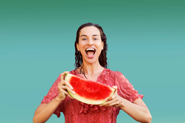 Femme gaie tenant un morceau de pastèque tranchée sur un fond coloré. Concept d'été - Photo, image